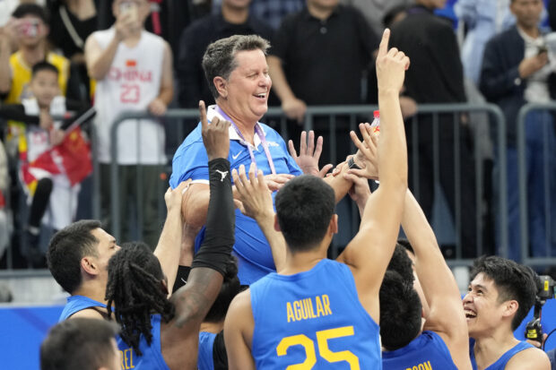Gilas Pilipinas players carry their head coach Tim Cone following their win over Jordan in the men's basketball gold medal match at the 19th Asian Games in Hangzhou, China, Friday, Oct. 6, 2023.